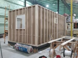 mobile office under construction, stud walls up with window openings visible
