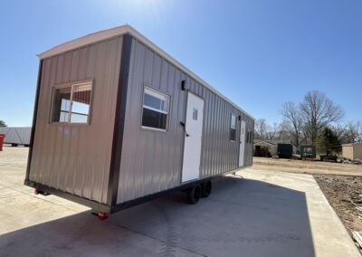 gray mobile office with two doors, 3 windows on side and one window on end