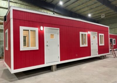 front exterior of red mobile office with 2 exterior doors and 3 windows